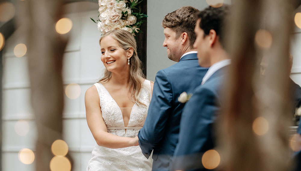 bride and groom pose in front of hotel