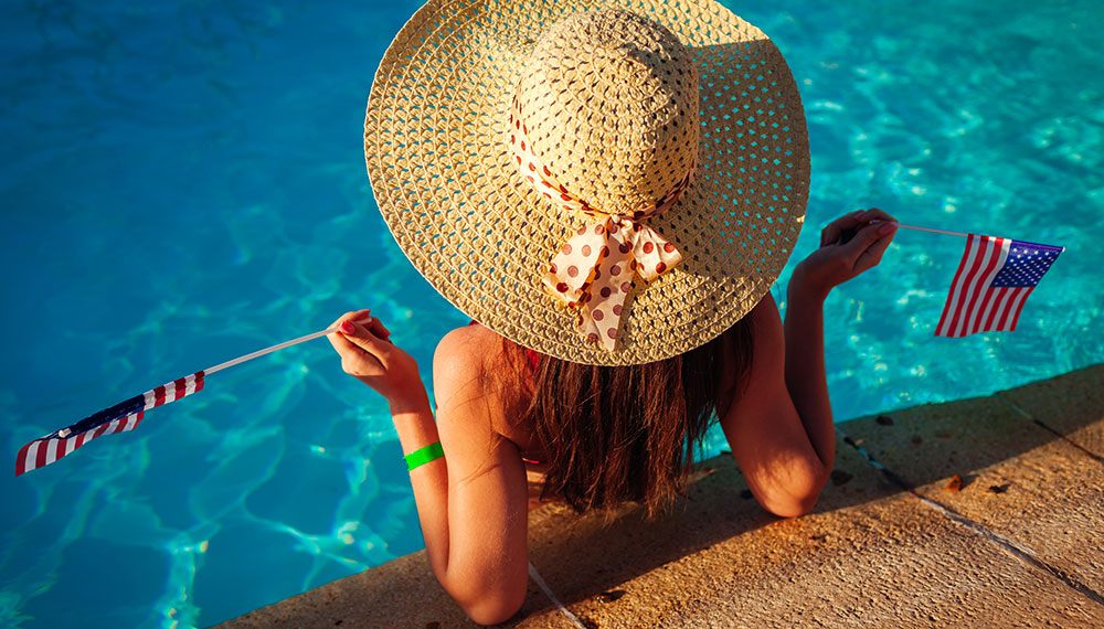 woman holding american flags in the pool